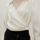 woman in white satin shirt and black bottoms