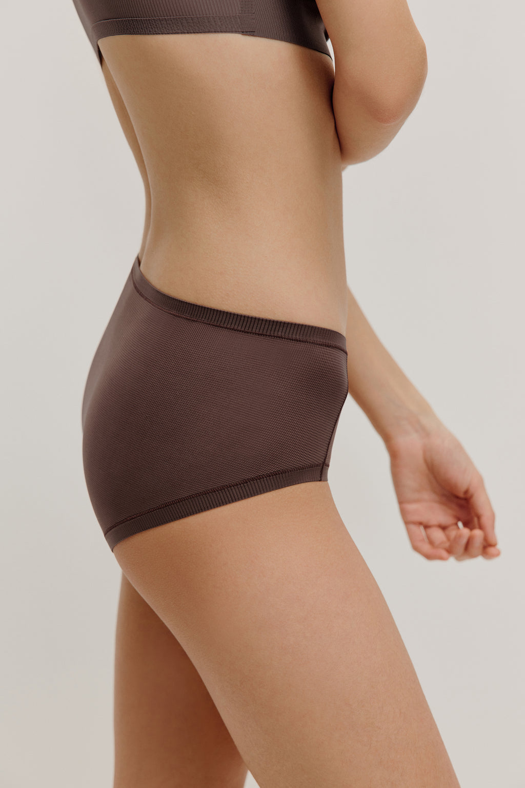 side of woman in dark purple brief