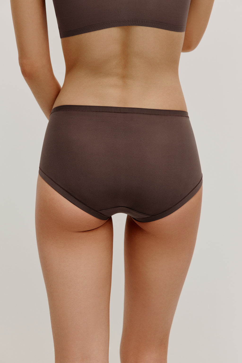 back of woman in dark purple brief