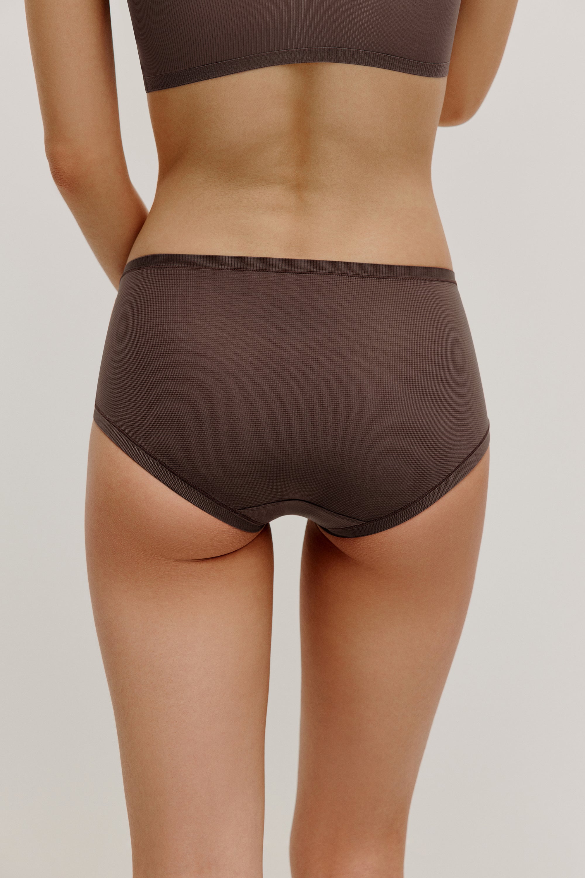 back of woman in dark purple brief