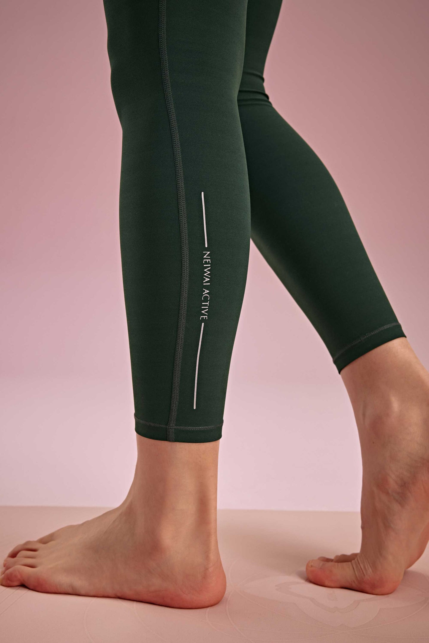 ankle detail of the green leggings shown neiwai active logo