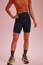 a woman wearing a brown tee and black biker shorts. pair with brown socks and shoes.