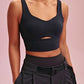 a woman wearing a long black sports bra and black pants
