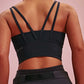 back of a woman wearing a black long sports bra and black pants.