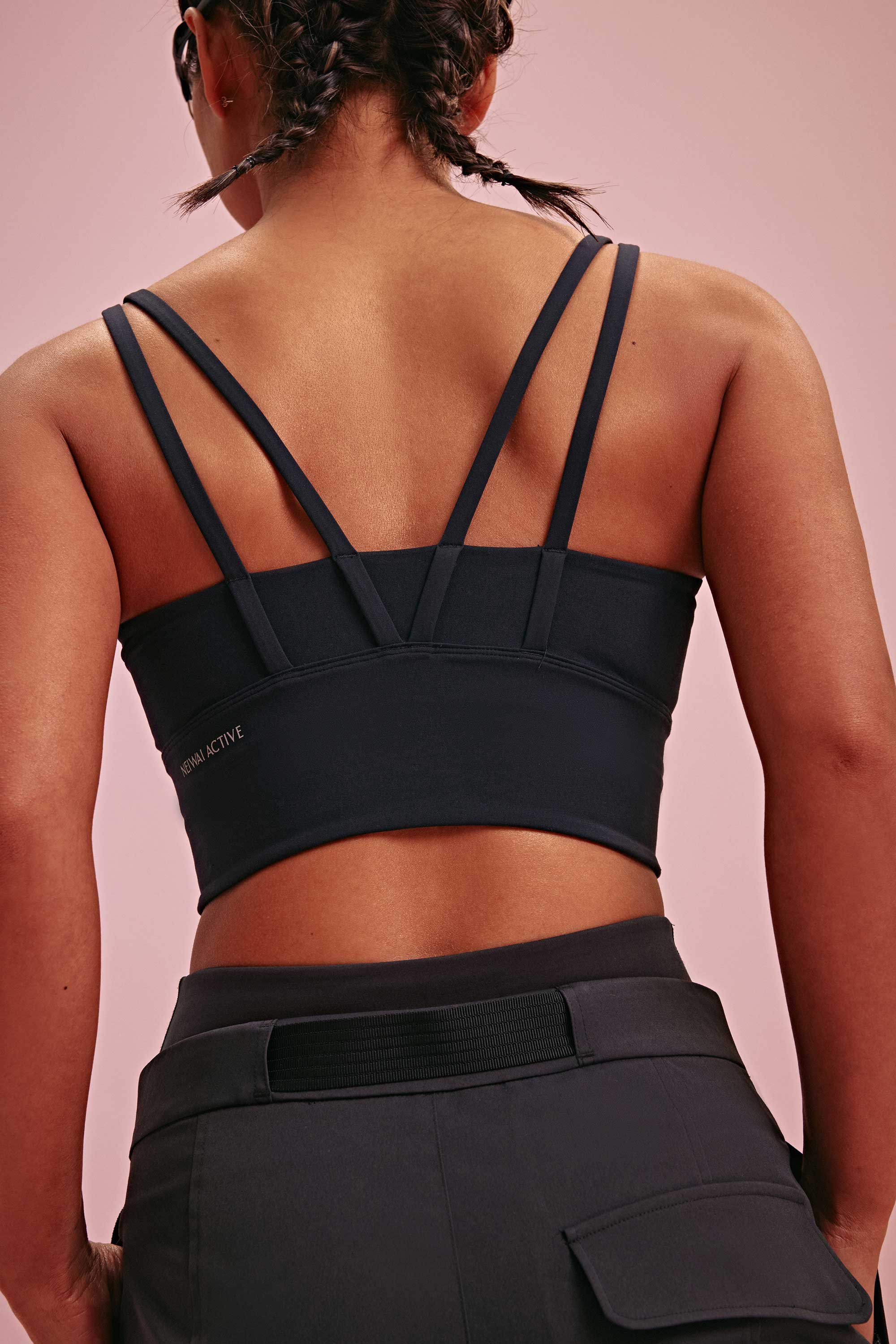 back of a woman wearing a black long sports bra and black pants.