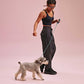 a woman wearing a black long sports bra and black pants with a dog