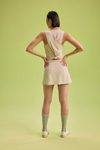 back a woman wearing a cream tank with knot and skirt