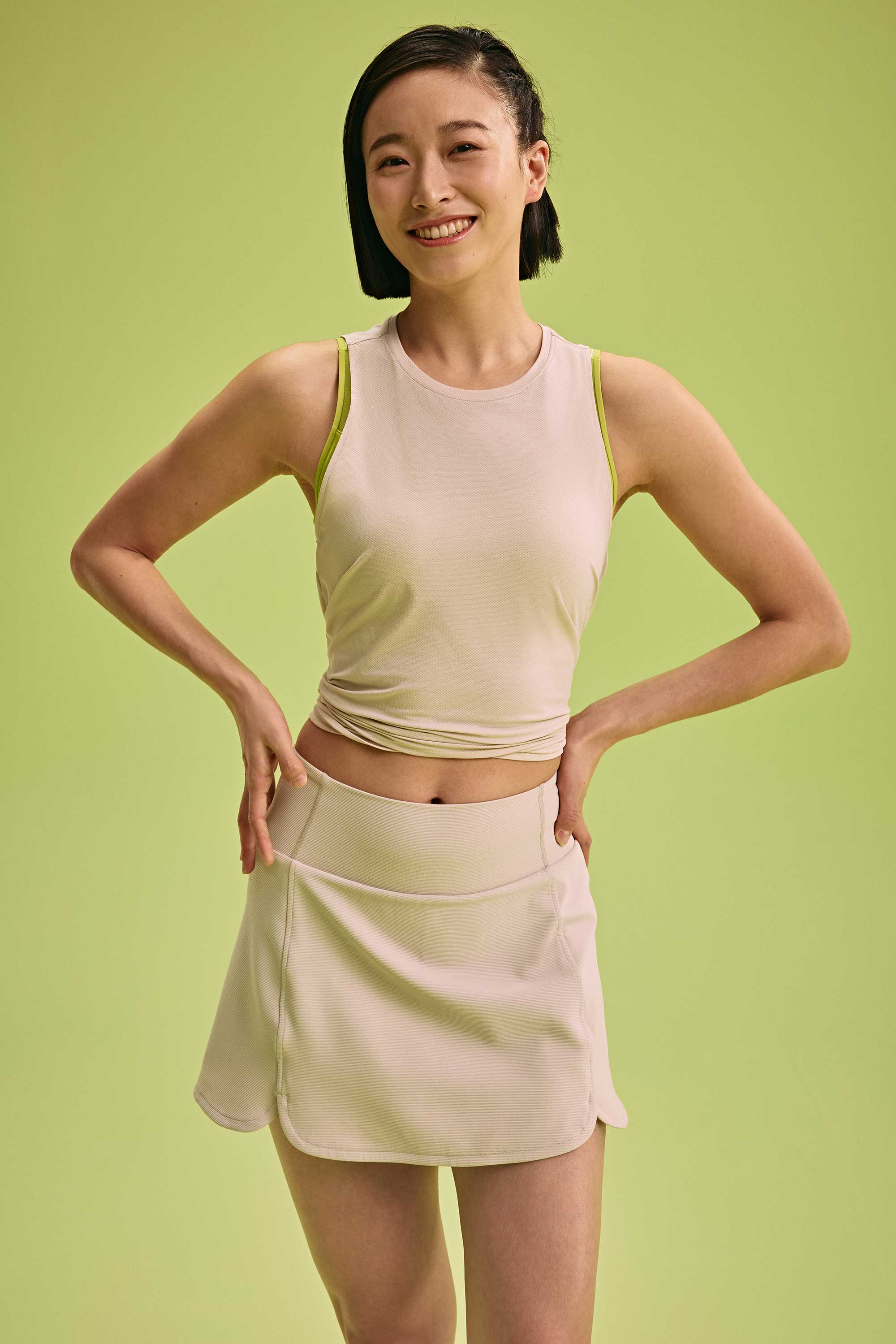 a woman wearing a cream tank and skirt