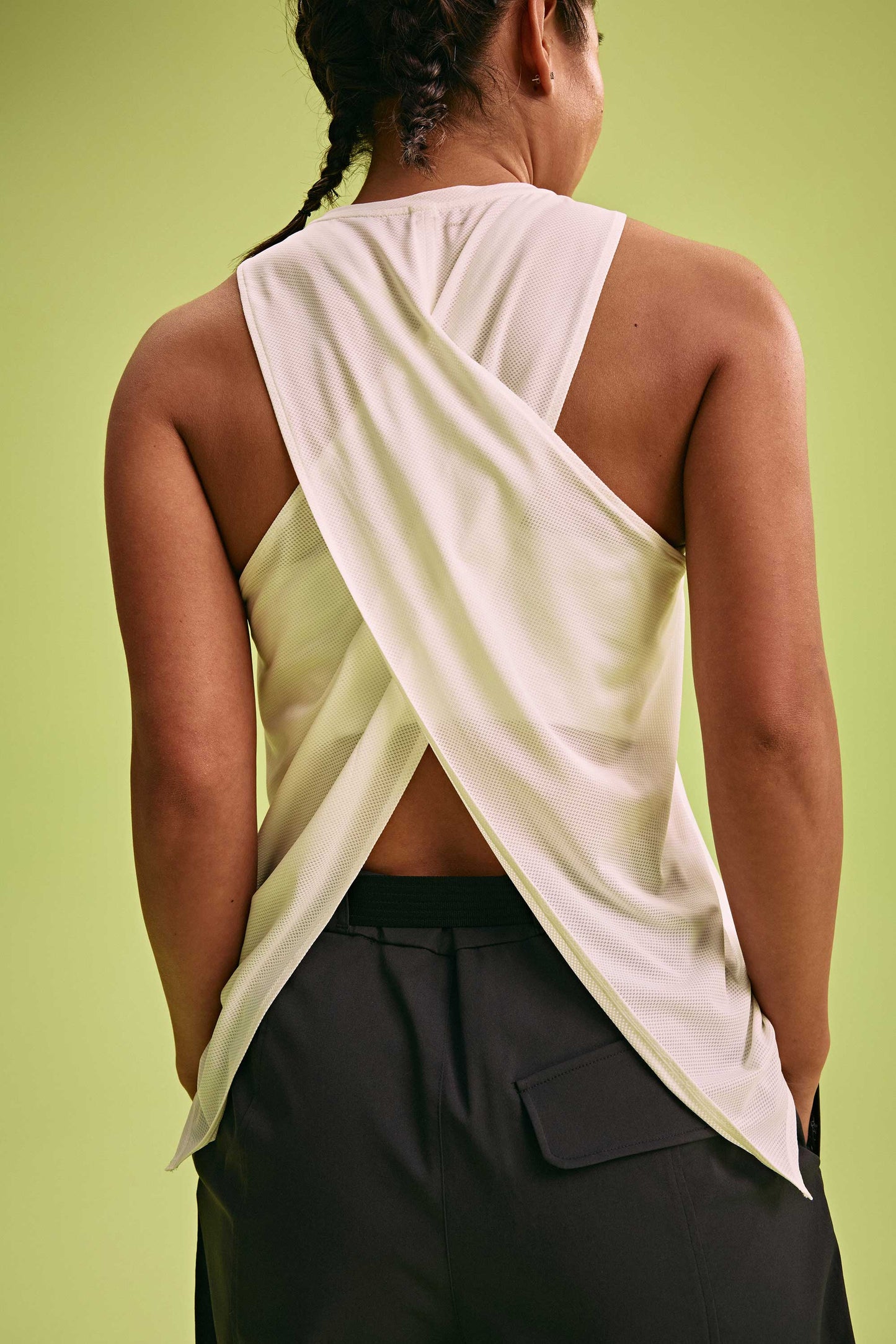 back of a woman wearing cross back tank and black pants