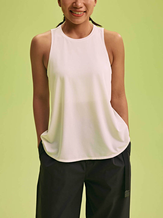 a woman wearing a white tank and black pants