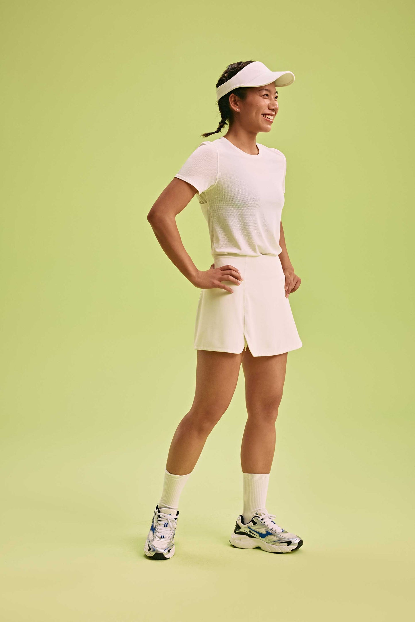 side view of a woman wearing white Cross-back T-Shirt and a hat and a white skirt