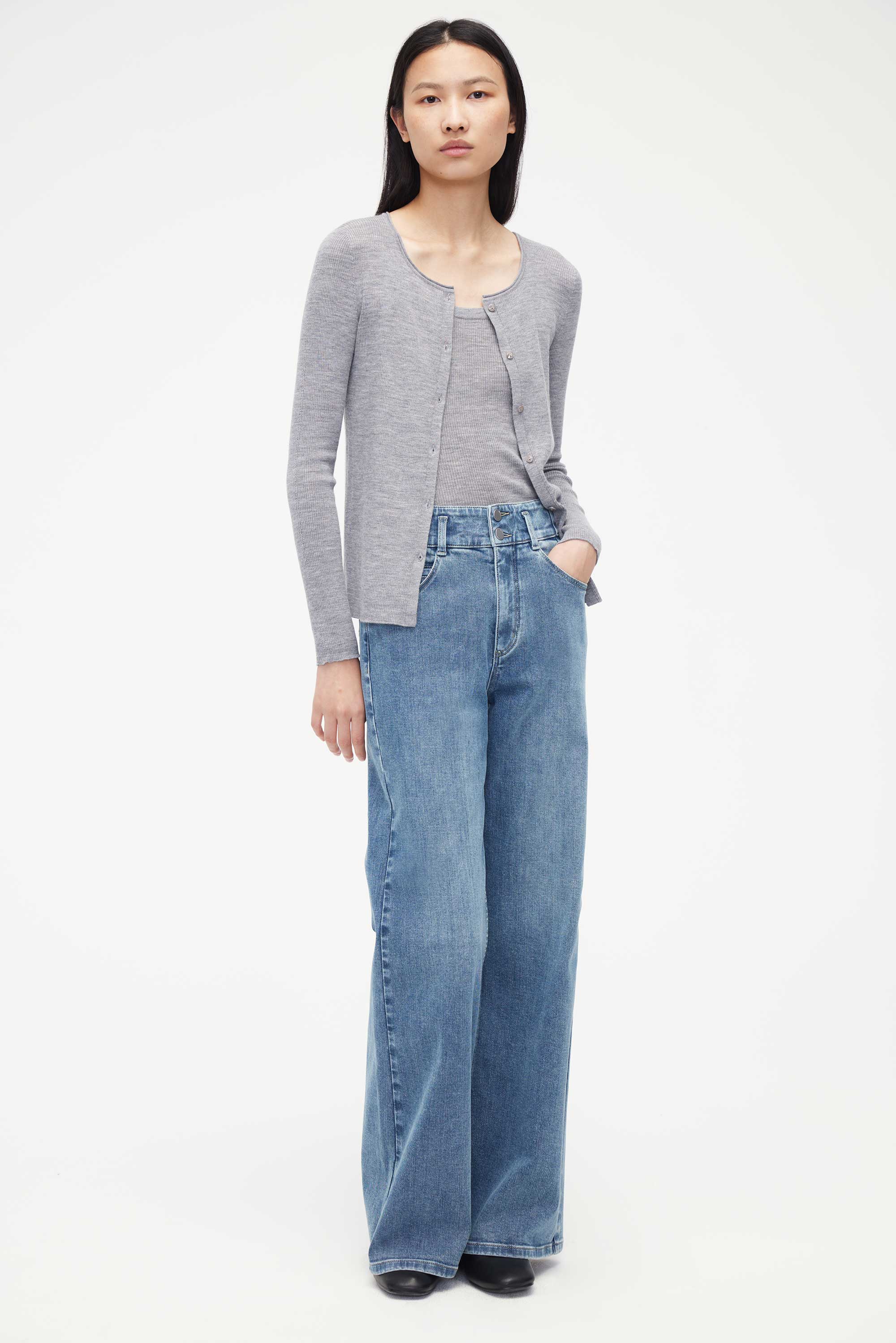 woman in grey cardigan with matching under layer and blue jeans