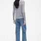 back of woman in grey cardigan and blue jeans