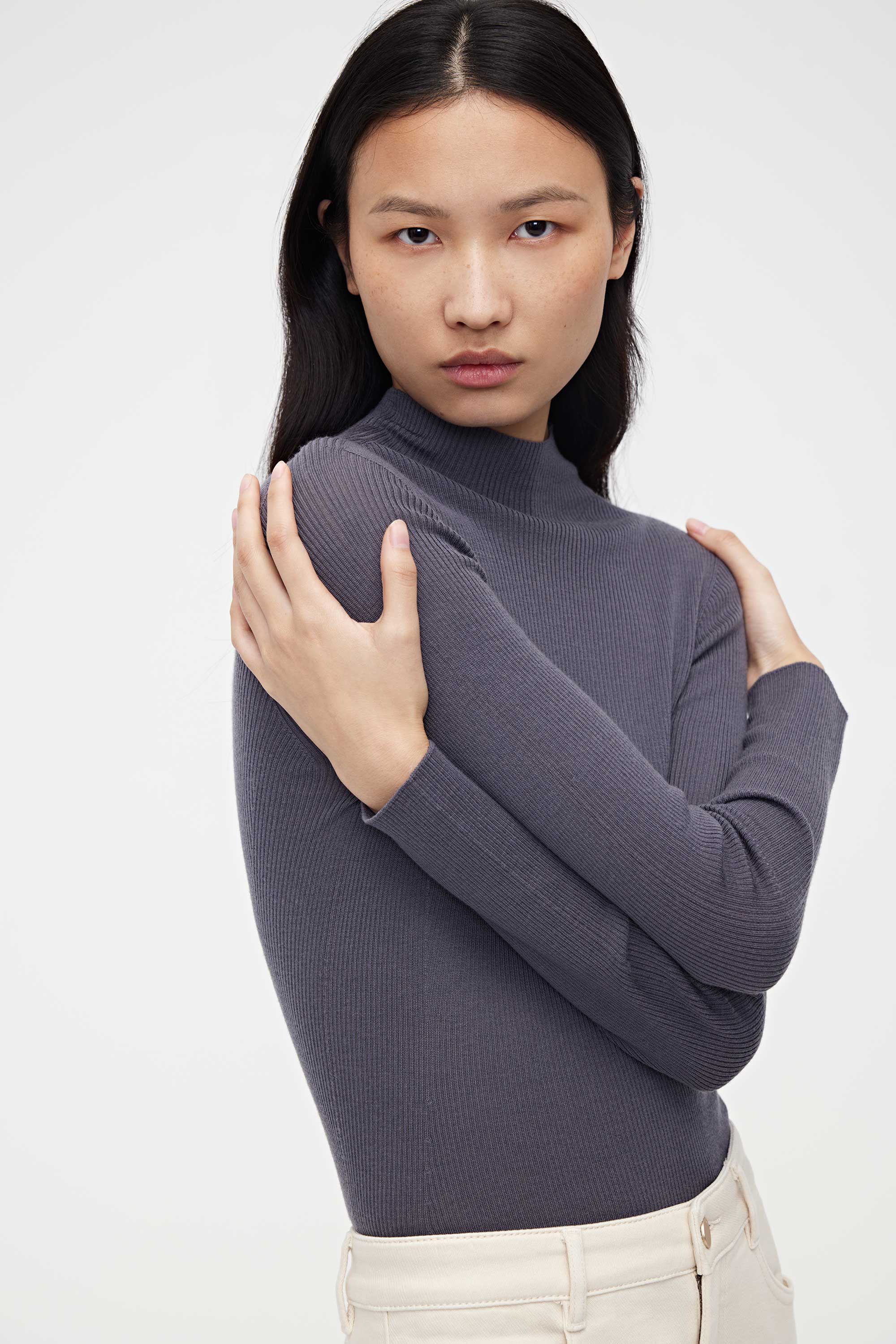 woman in purple mock neck sweater