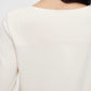 close up of back of woman in cream pajama tee