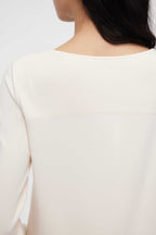 close up of back of woman in cream pajama tee