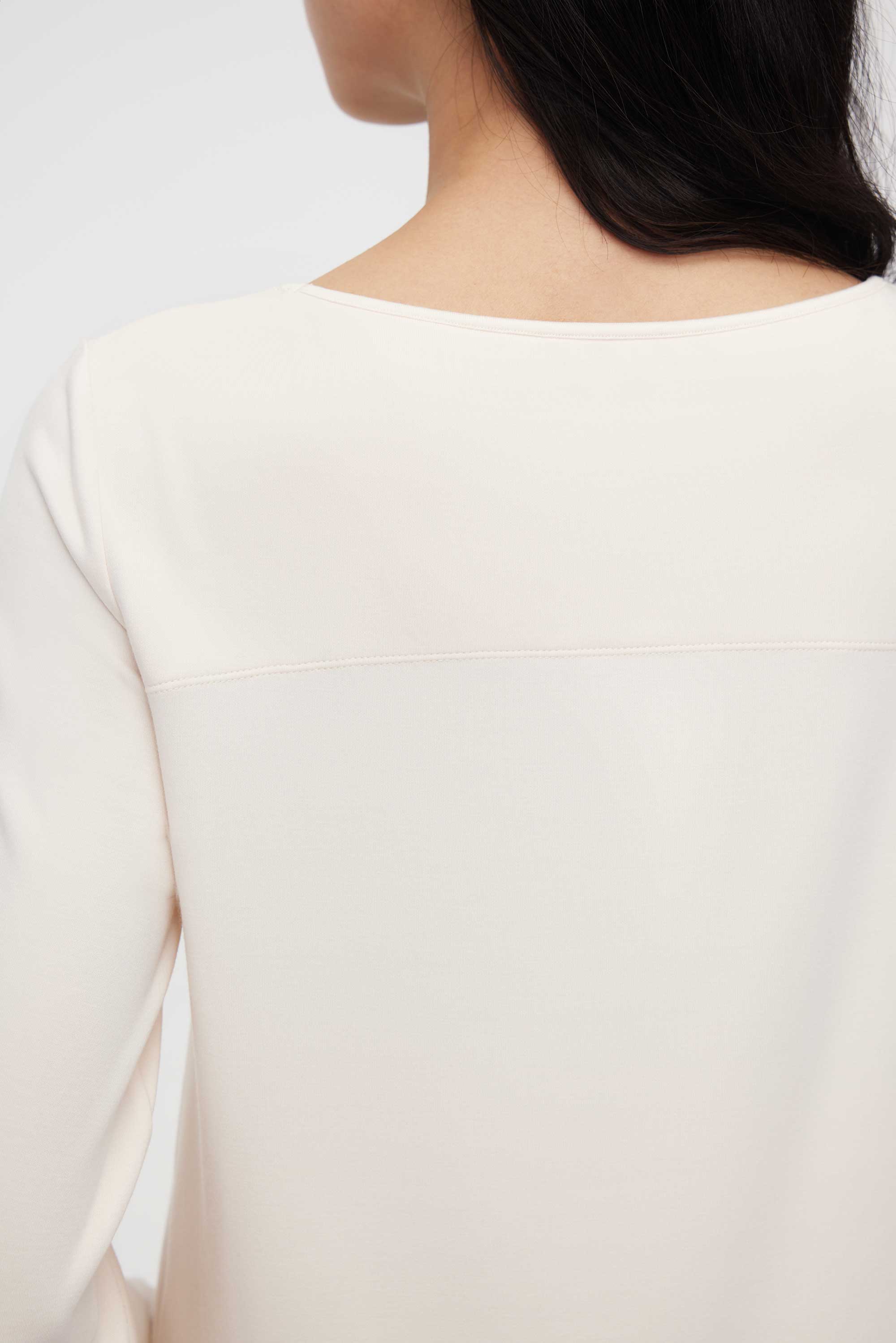 close up of back of woman in cream pajama tee