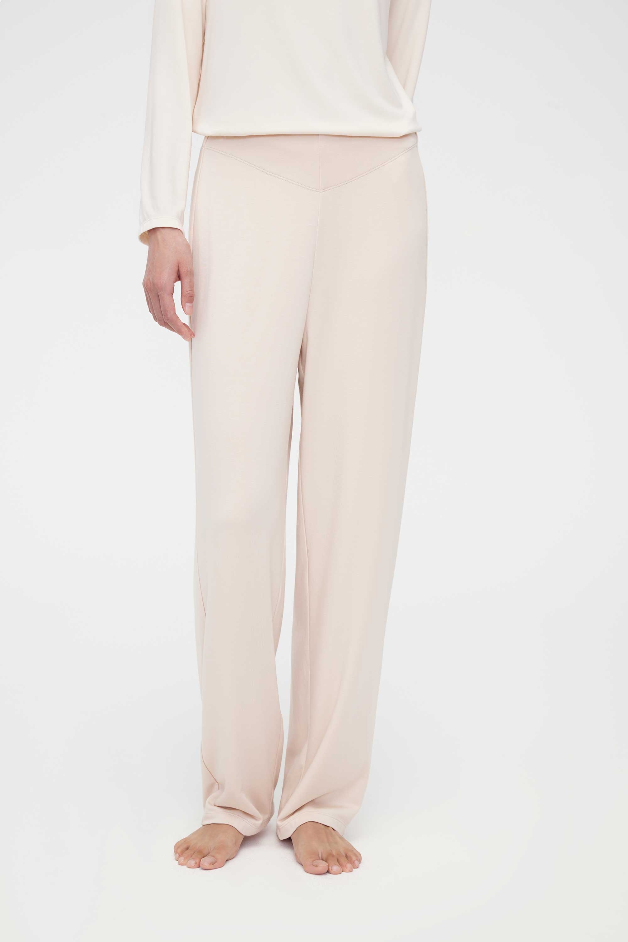 A woman wears a cream pajama set