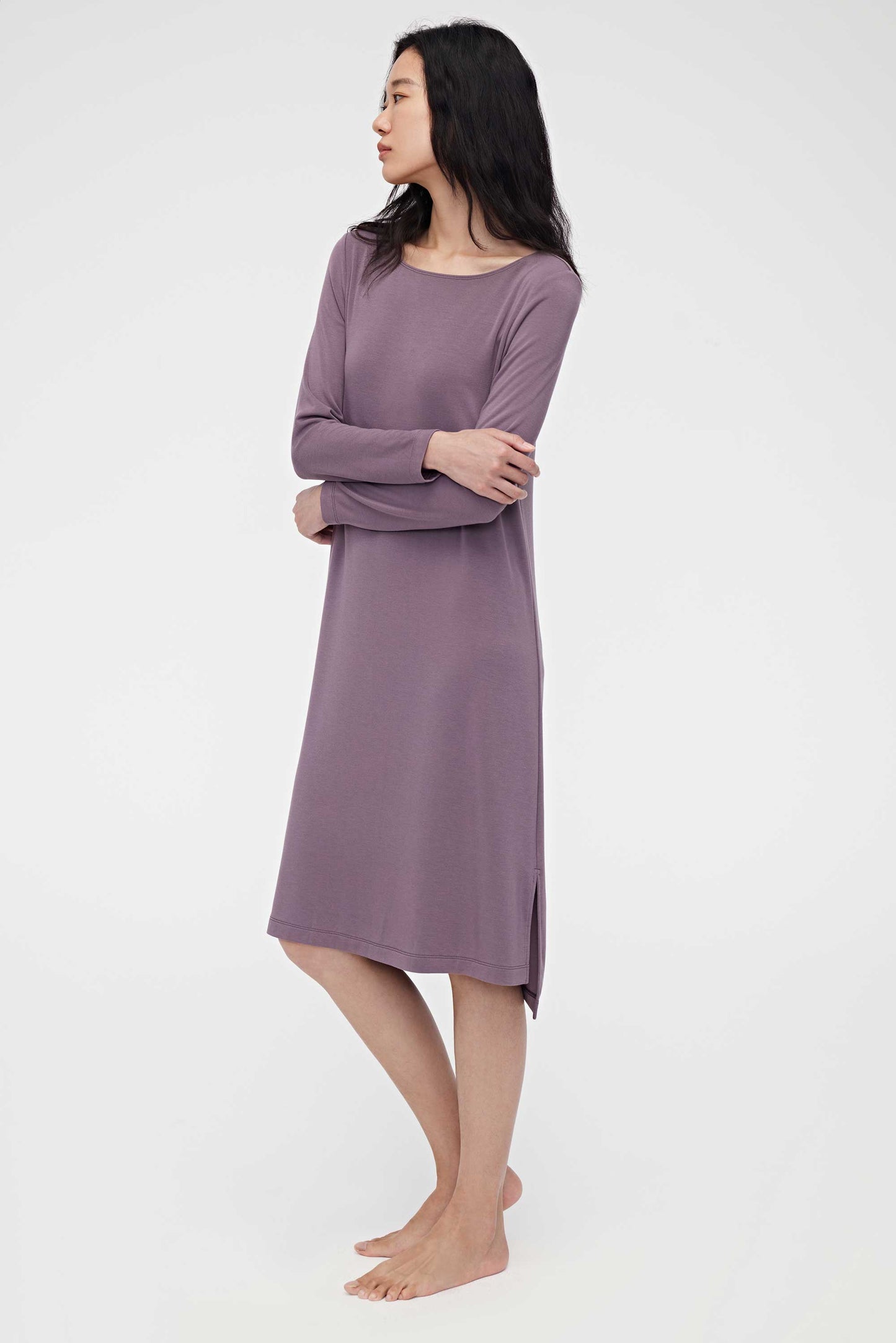 Woman wearing purple pajama dress and facing left