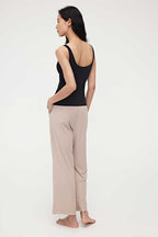 the back of woman in black tank top and pink lounge pants