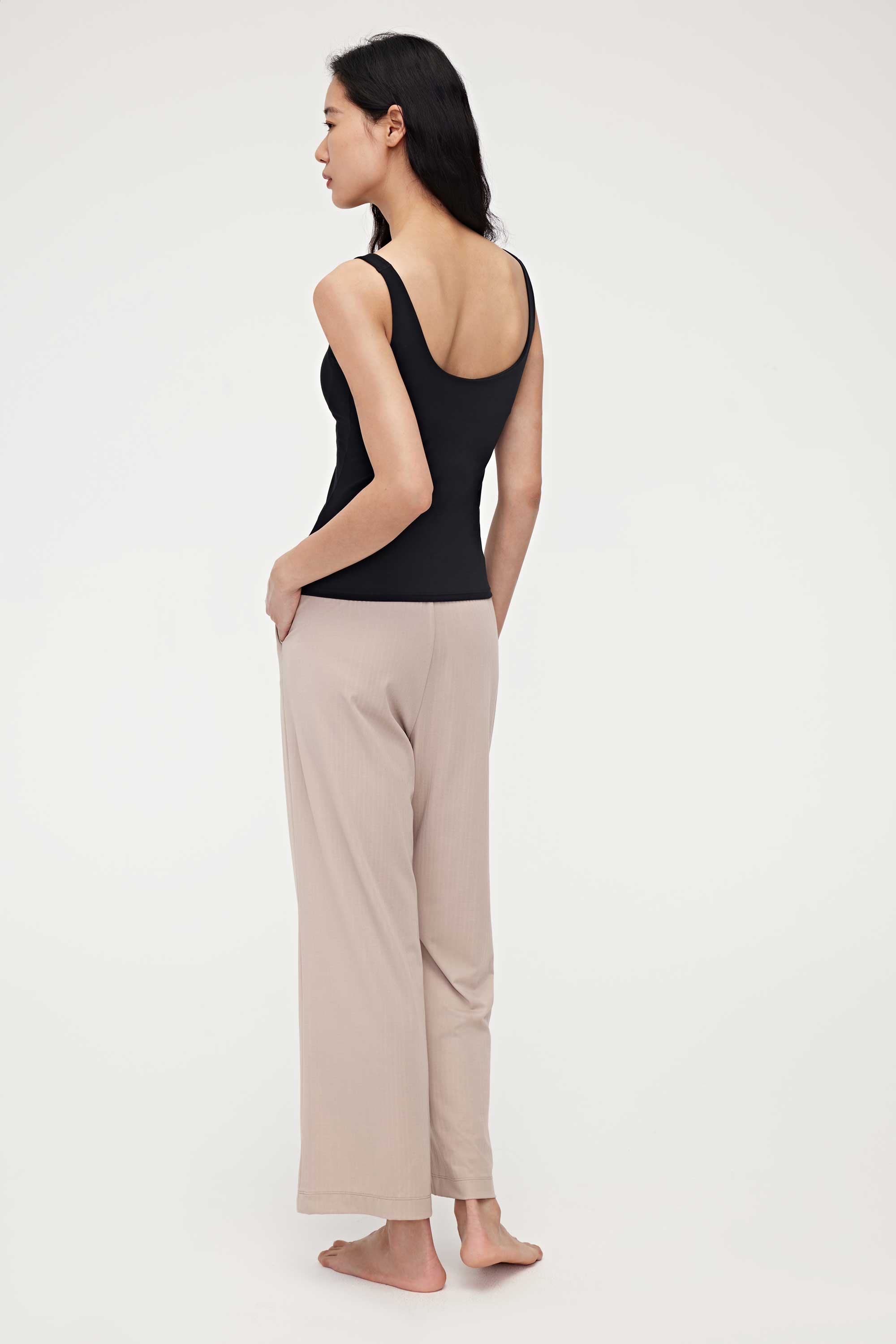 the back of woman in black tank top and pink lounge pants