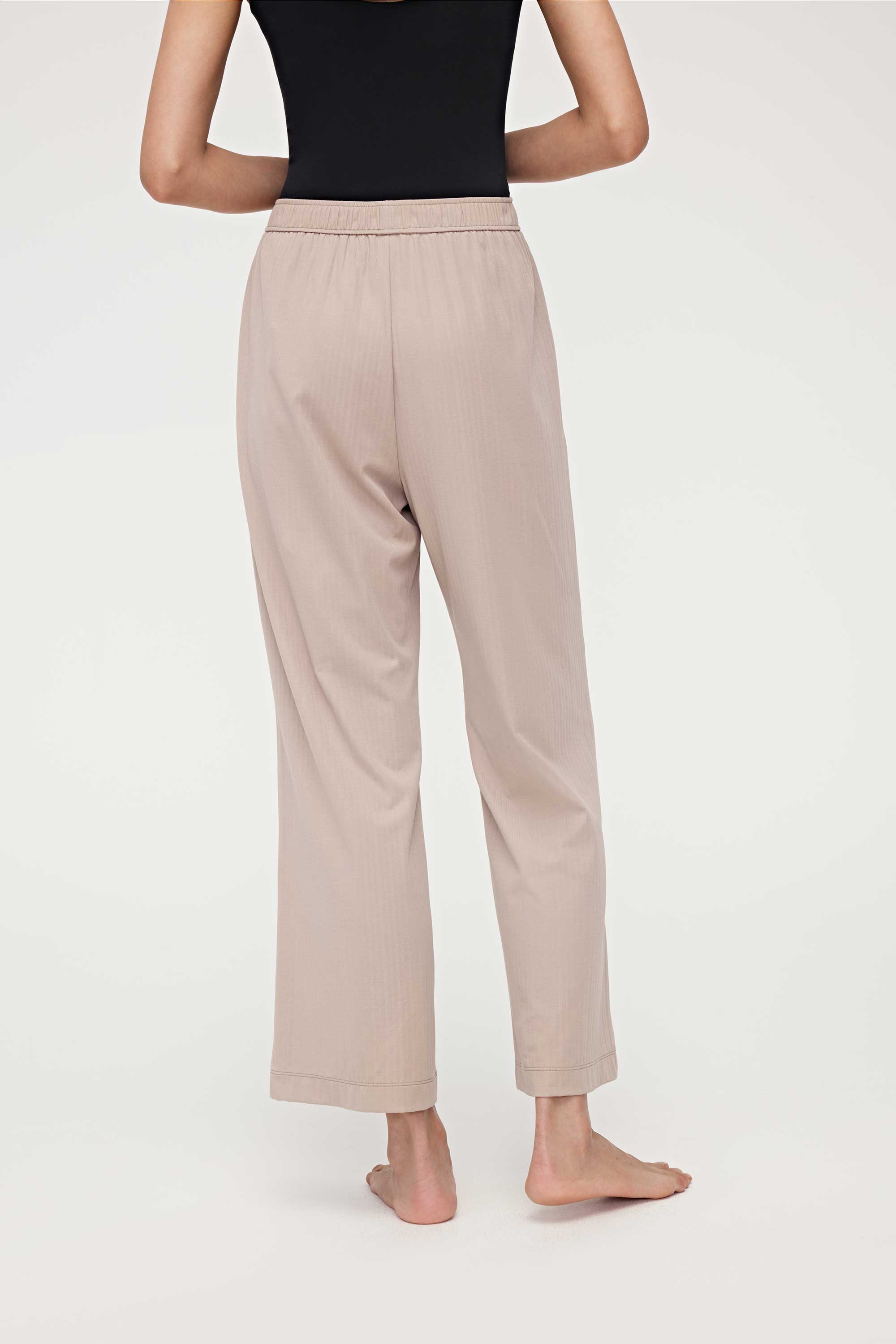 back of woman in black tank top and coffee lounge pants