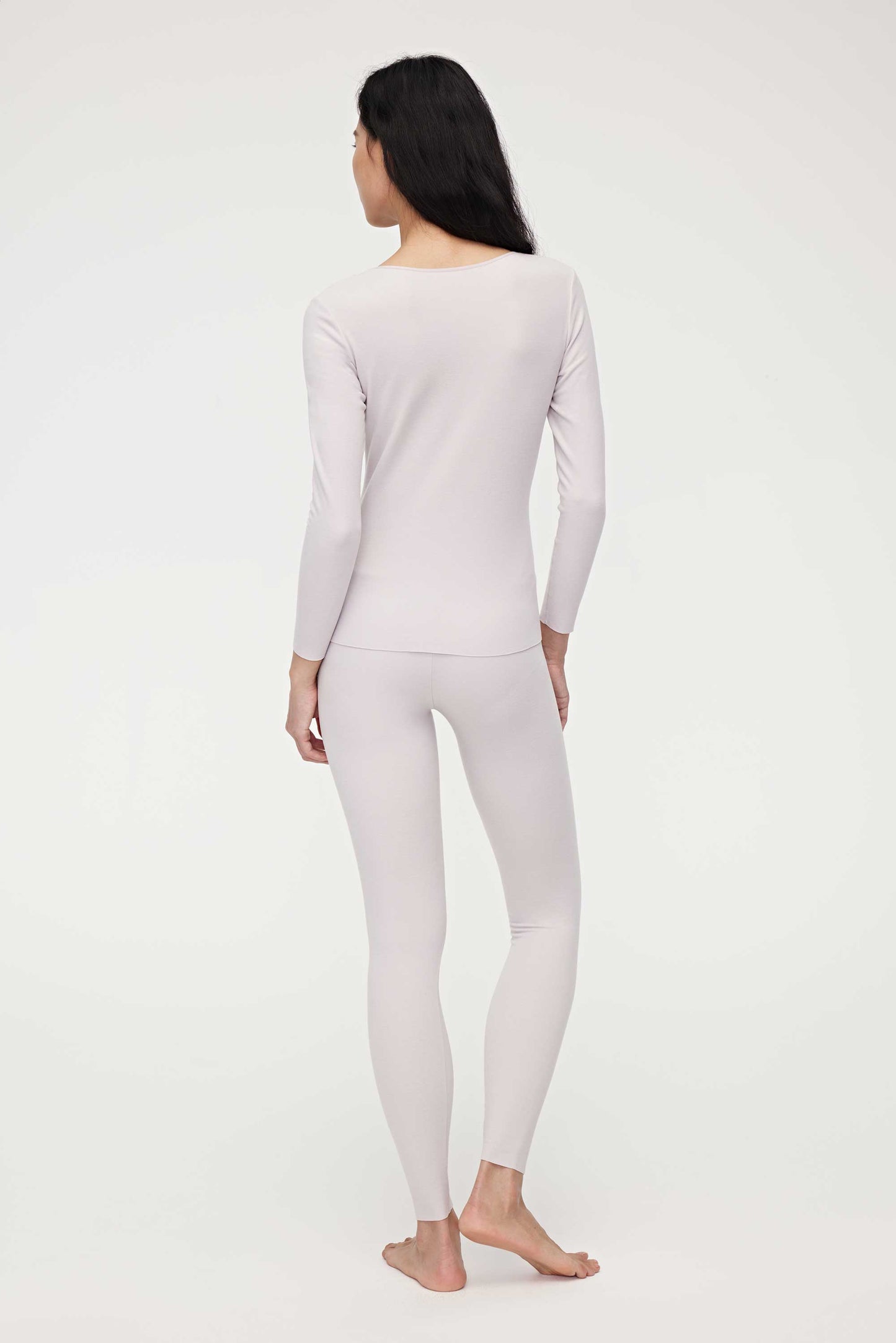 back of woman in light pink thermal wear set