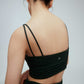 the back a woman wearing a dark green double strap sports bra with pleats details