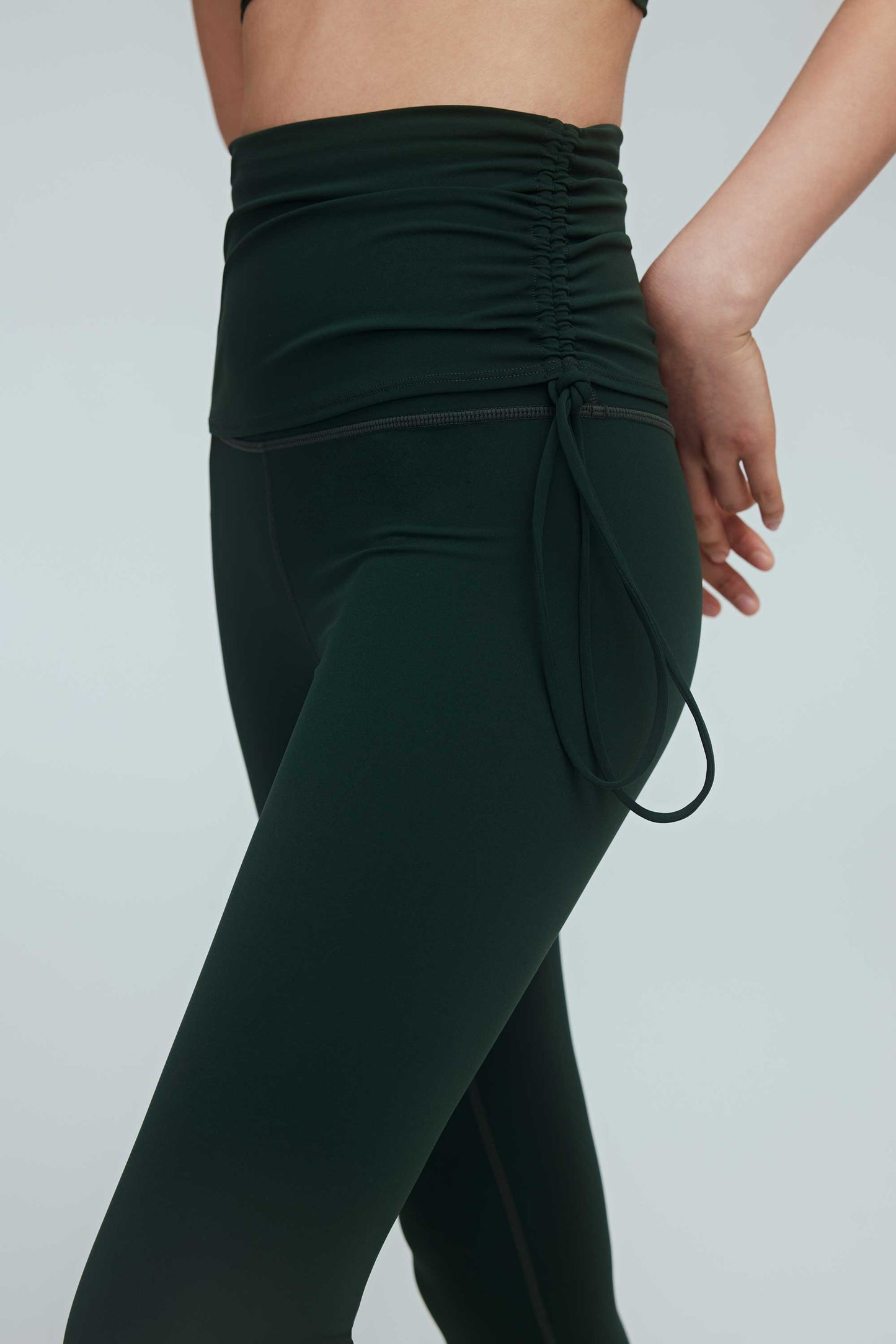 side of a woman wearing a green drawstring leggings