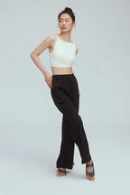 a woman wearing a brown joggers and white sports bra