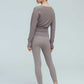 back of a woman wearing a taupe wrap sweater and leggings.