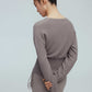 back of a woman wearing a taupe wrap sweater and leggings.