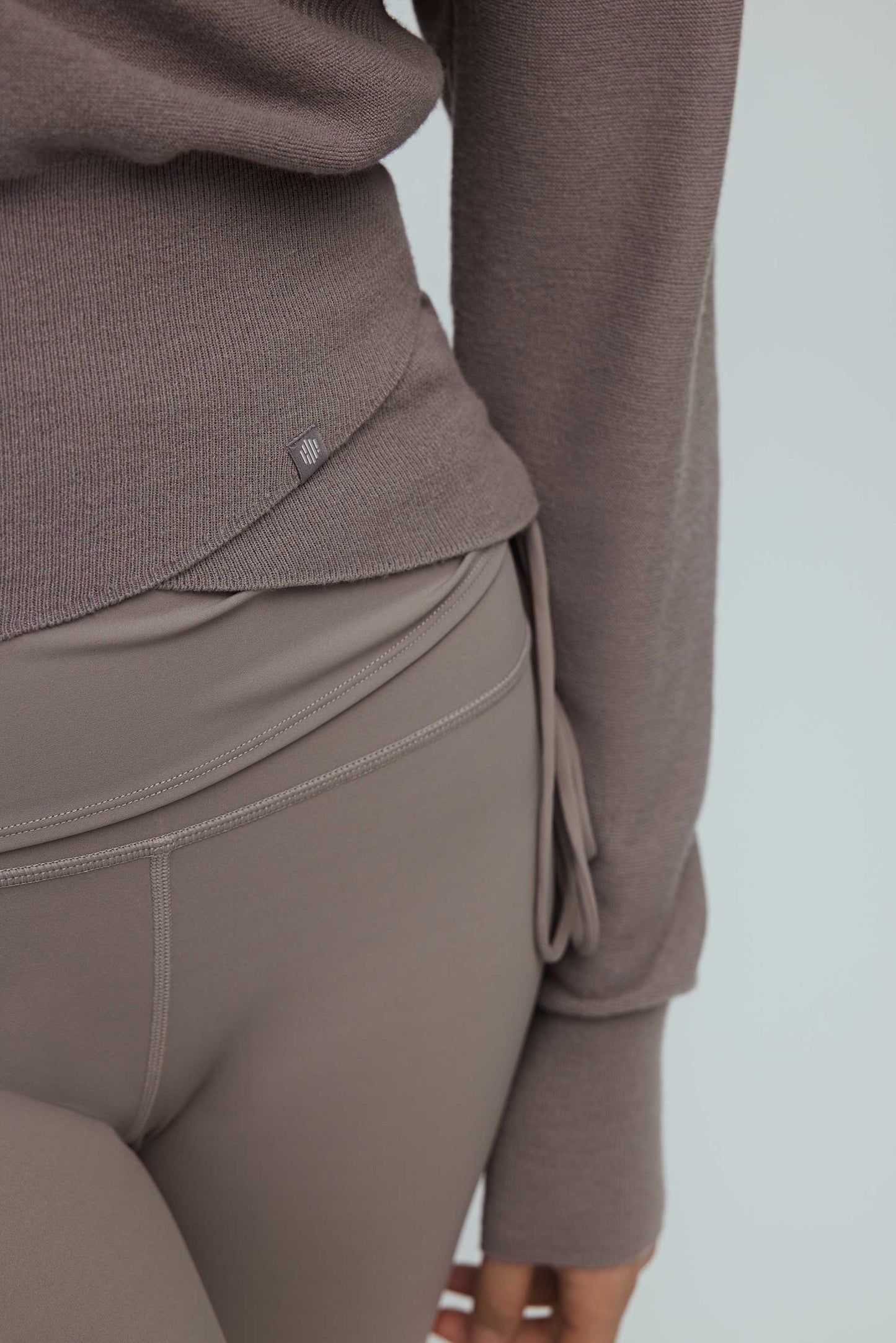 detail shot of taupe wrap sweater and leggings.