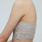 The side close look of a light grey sports bra with ruched texture details