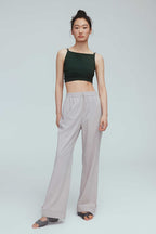 a woman wearing a grey joggers and green sports bra