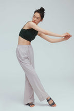 a woman wearing a grey joggers and green sports bra 