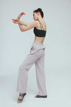 back of a woman wearing a grey joggers and green sports bra