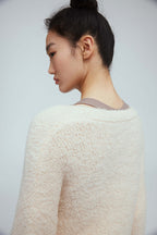back of a woman wearing white wool cardigan 