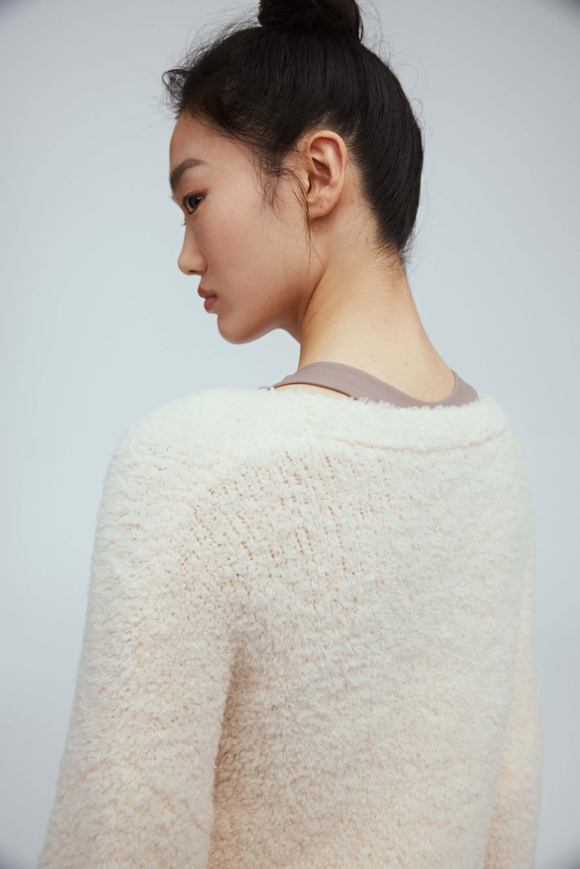 back of a woman wearing white wool cardigan 