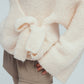 detail shot of white wool cardigan knot