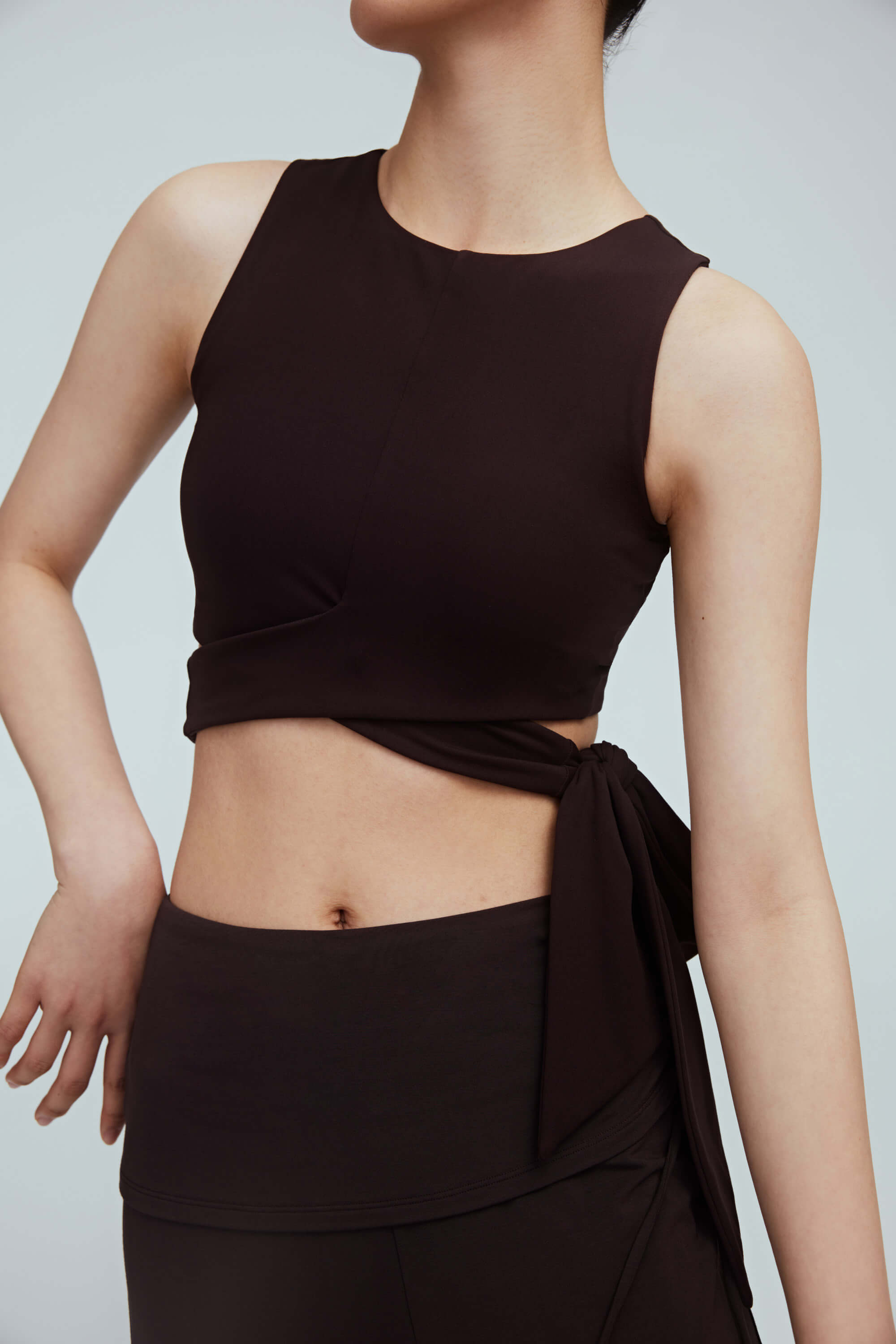 a woman wearing a brown wrap bra top and brown leggings