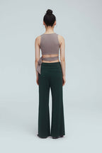 back of a woman wearing a light brown wrap bra top and green leggings
