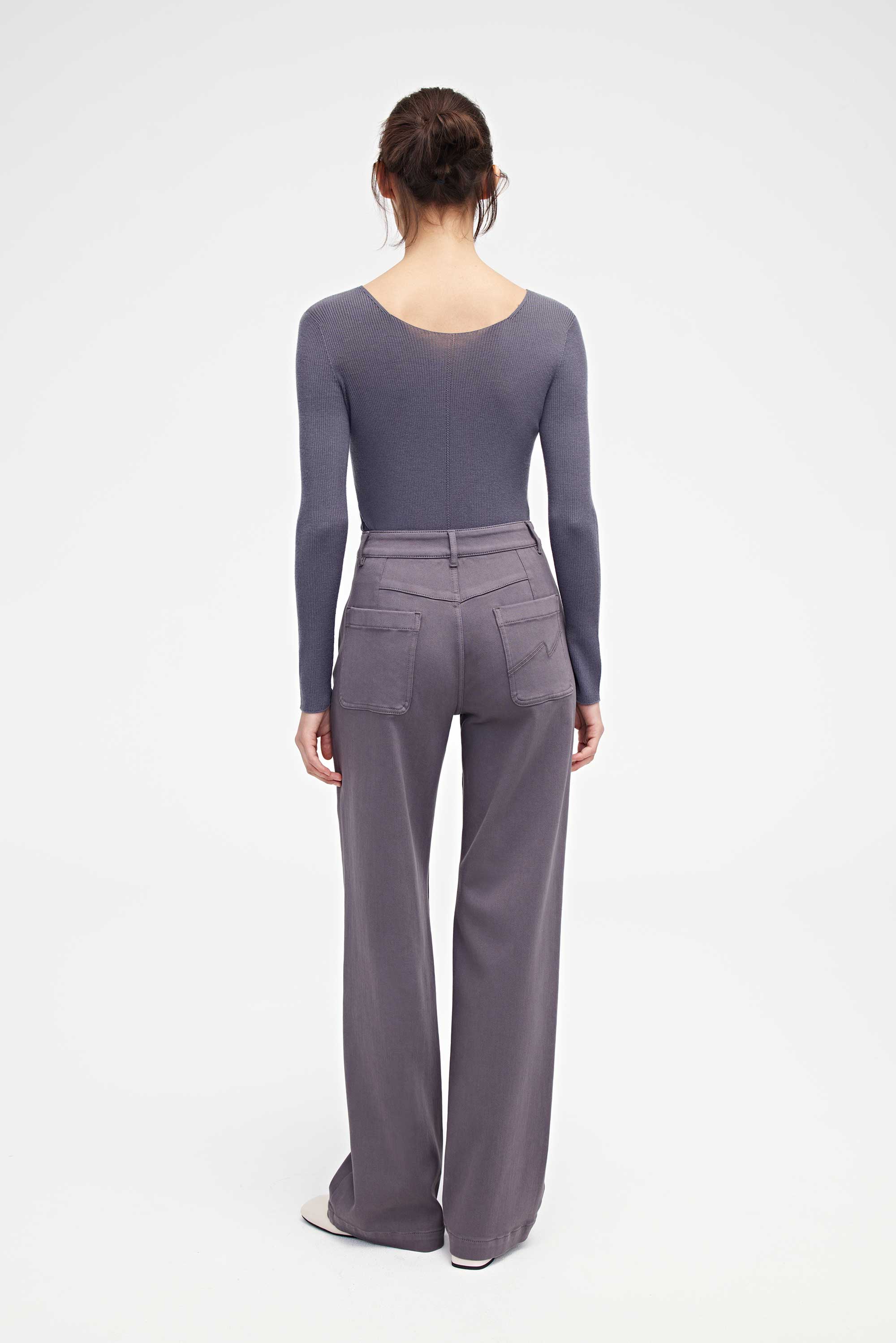 back of woman in purple v neck sweater