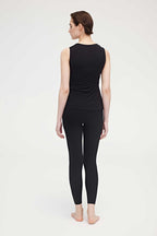 Back side of woman wearing black tank top and leggings