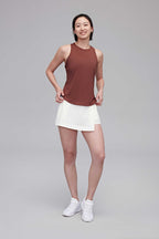 woman in reddish brown tank and white shorts