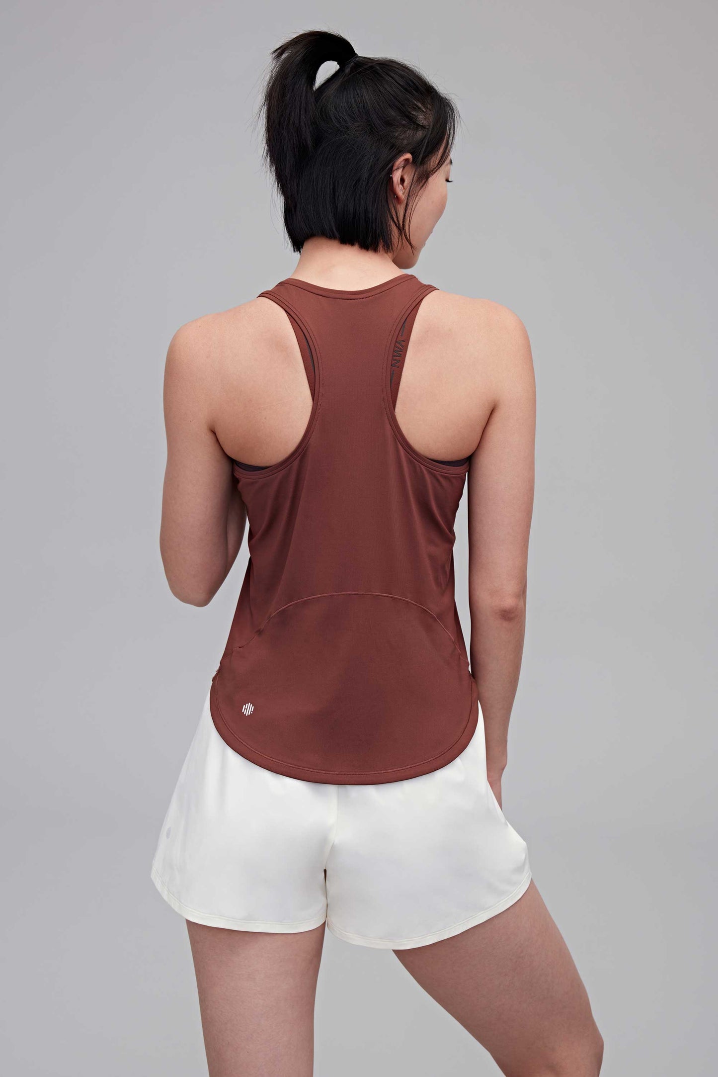 back of woman in reddish brown tank