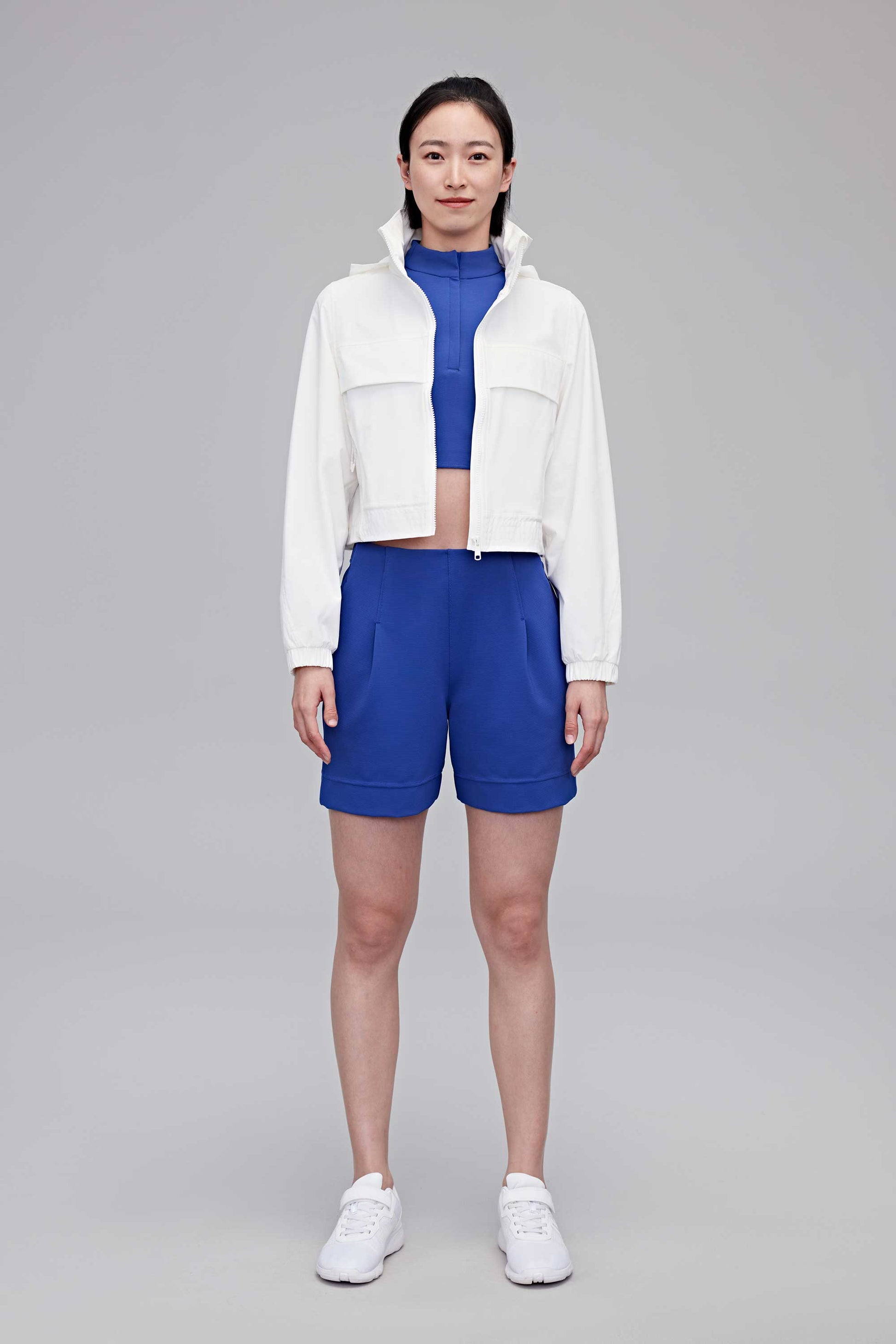 woman in white jackets, blue tank and blue shorts