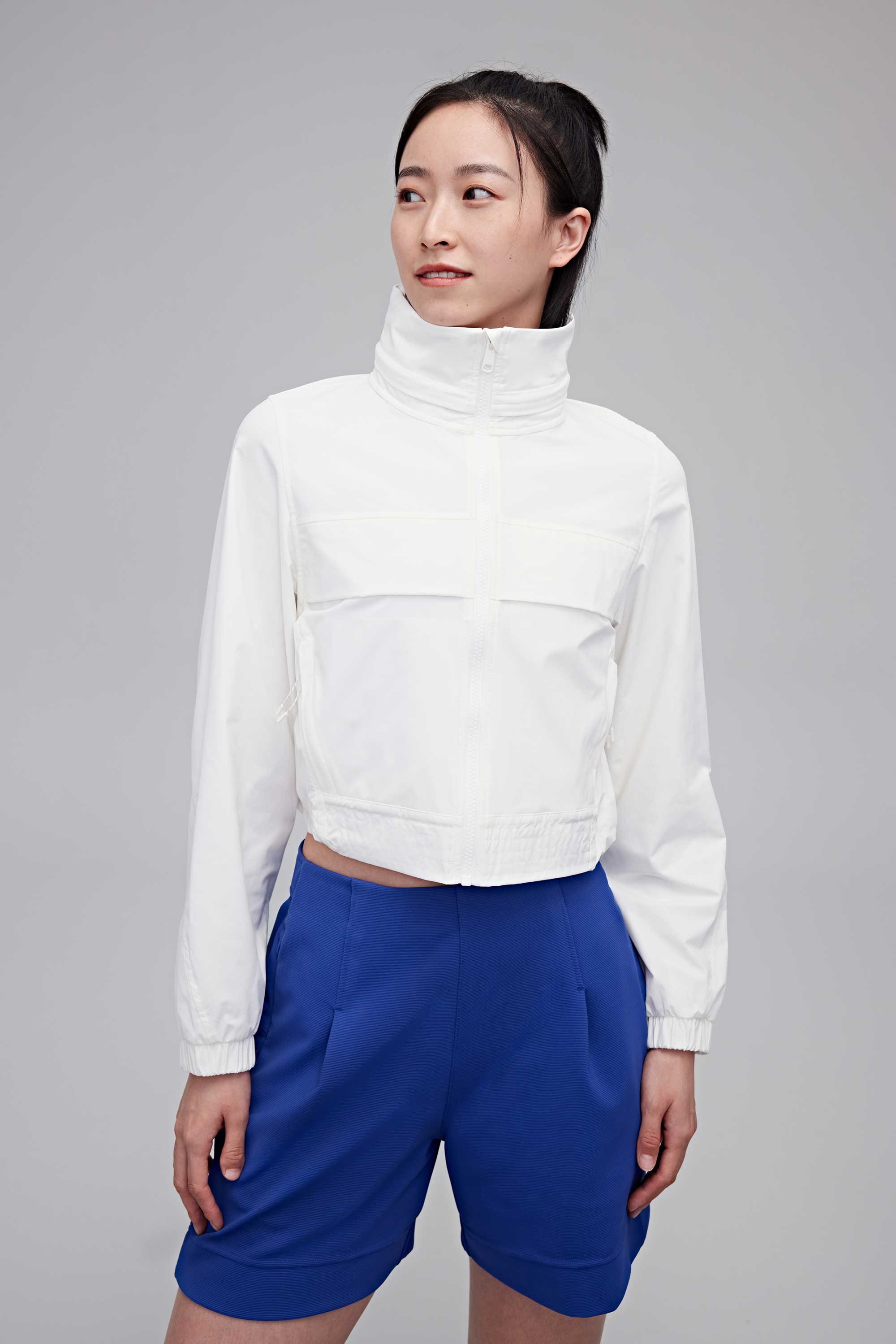 woman in white jacket and blue shorts