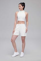woman in white tank and white shorts
