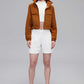 woman in brown jacket and white shorts